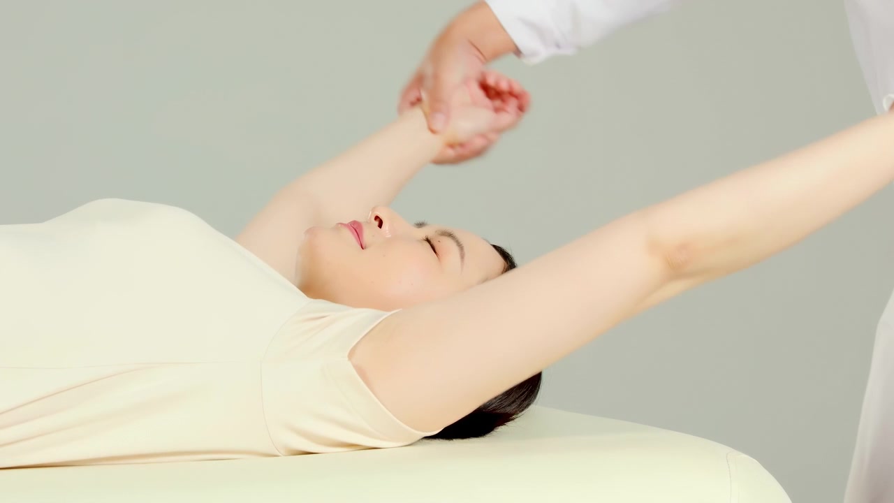 Massaggiatore esperto, fisioterapista ortopedico esegue un massaggio riabilitativo di fisioterapia per trattare la spalla, la schiena, il collo e la colonna vertebrale di una paziente durante un controllo medico, eseguendo stretching