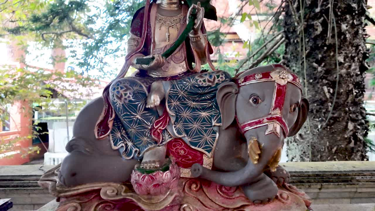 Intricate Buddhist deity statue riding an elephant symbolizing tradition and spirituality in Thailand
