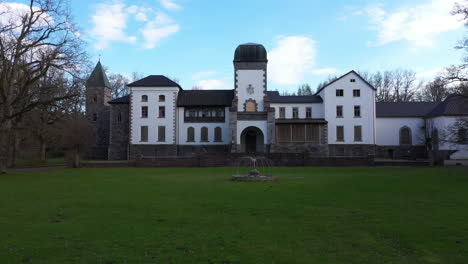 historic white mansion with tower in landscaped grounds