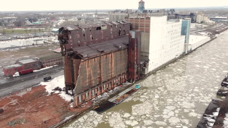 large abandoned factory next to frozen river