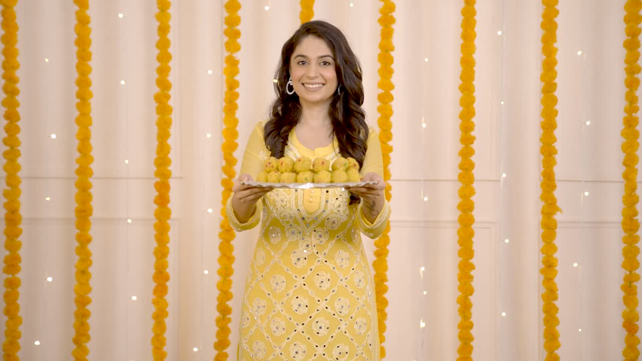 mujer india deseando feliz diwali con dulces