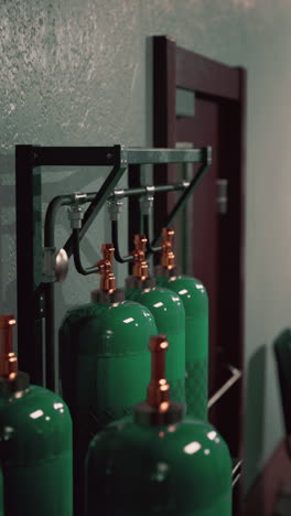 green gas cylinders stored on a metal rack