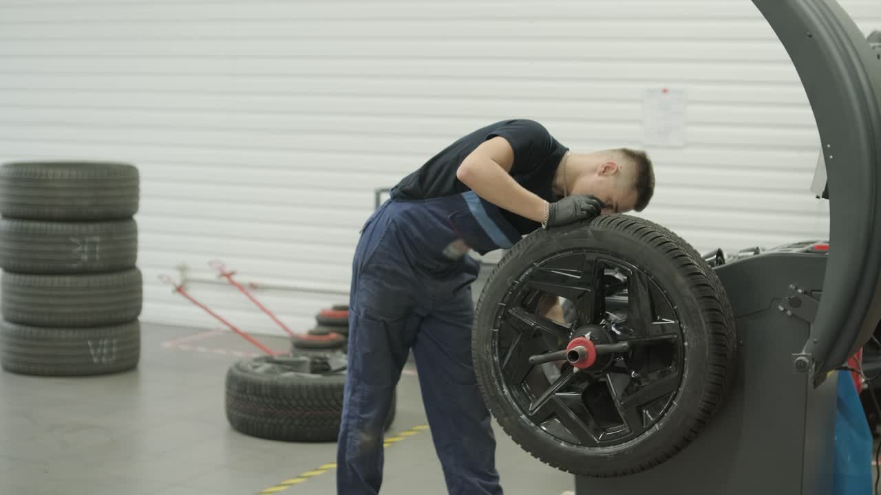 Mechanic Repairing Tire in Auto Service Garage