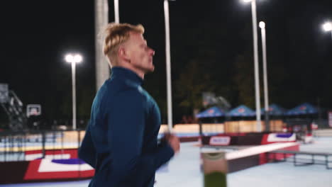 focused blond man running in the park at night 1