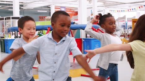 cinco niños bailando y divirtiéndose en un centro de ciencias
