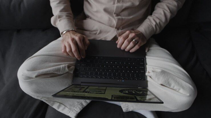 Una persona seduta che utilizza un laptop