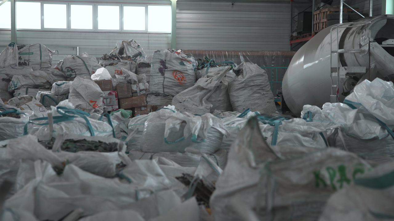 Crowded Recycling Bags Beneath Large Windows, Industrial Mixer At Side, Chaotic Foreground Pile, Cool Ambient . Media