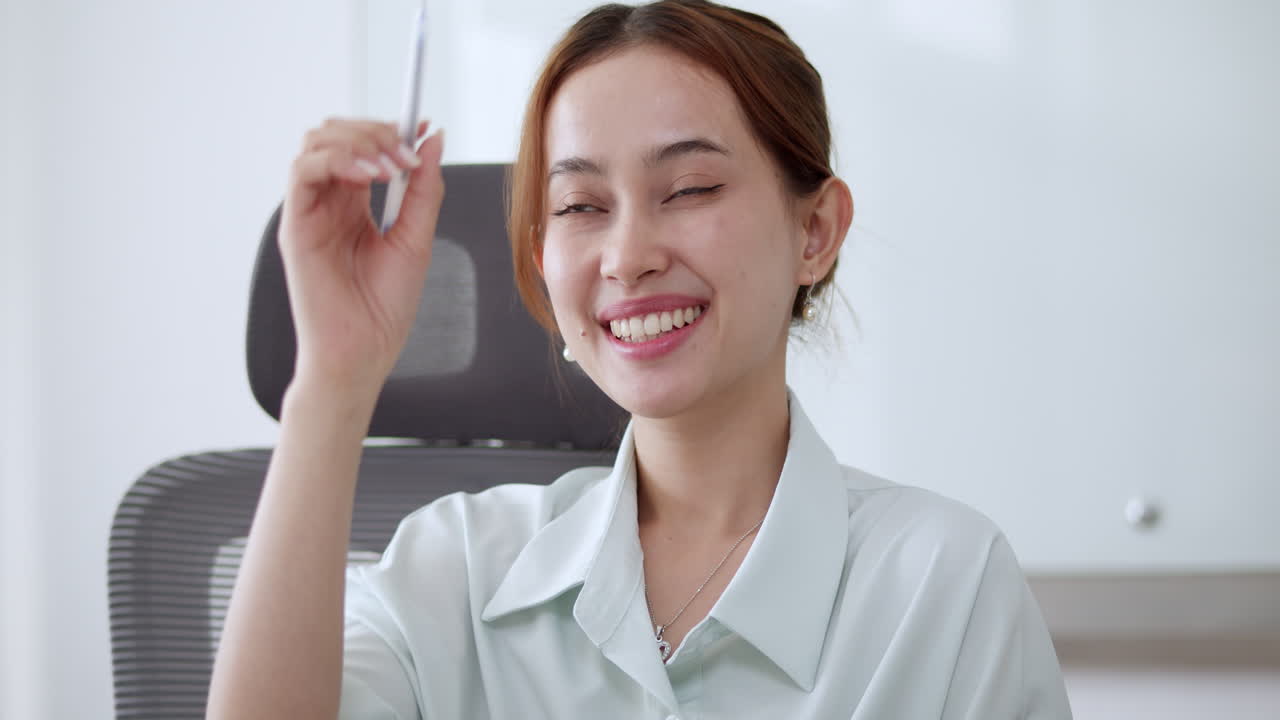 A corporate woman listening in a meeting, raising her hand, and motioning her ideas to others.