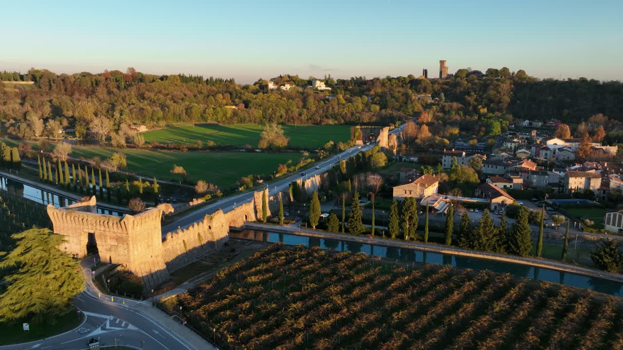 Forward Drone Shot of Visconteo's Bridge passing over the cars crossing at Golden Hour with birds storm at the end
