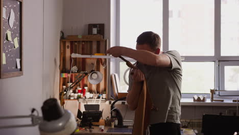 craftsman takes off vintage apron finishing work in shop