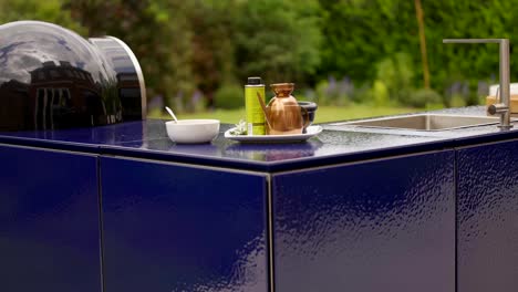 outdoor kitchen with utensils and pizza oven on the work surface