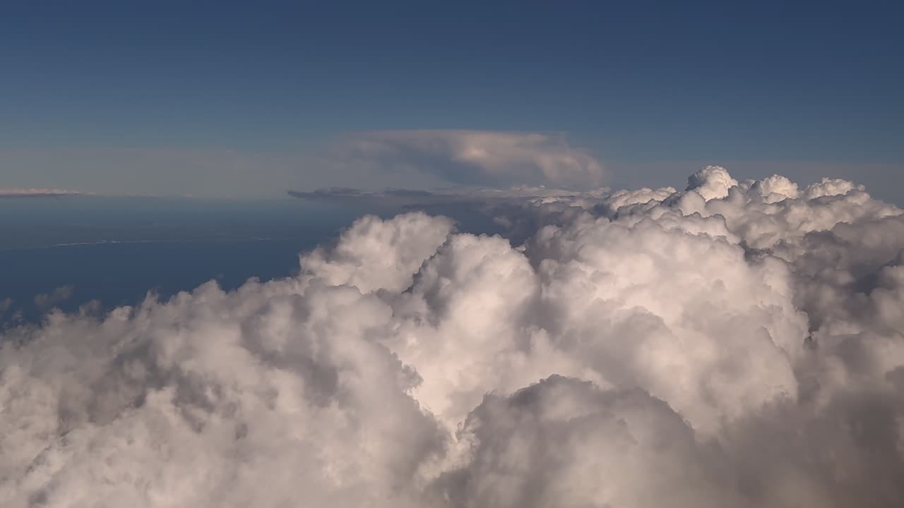 An immersive pilot’s eye view while flying over a huge storm cumulonimbus cloud over the Mediterranean Sea at the blue hour