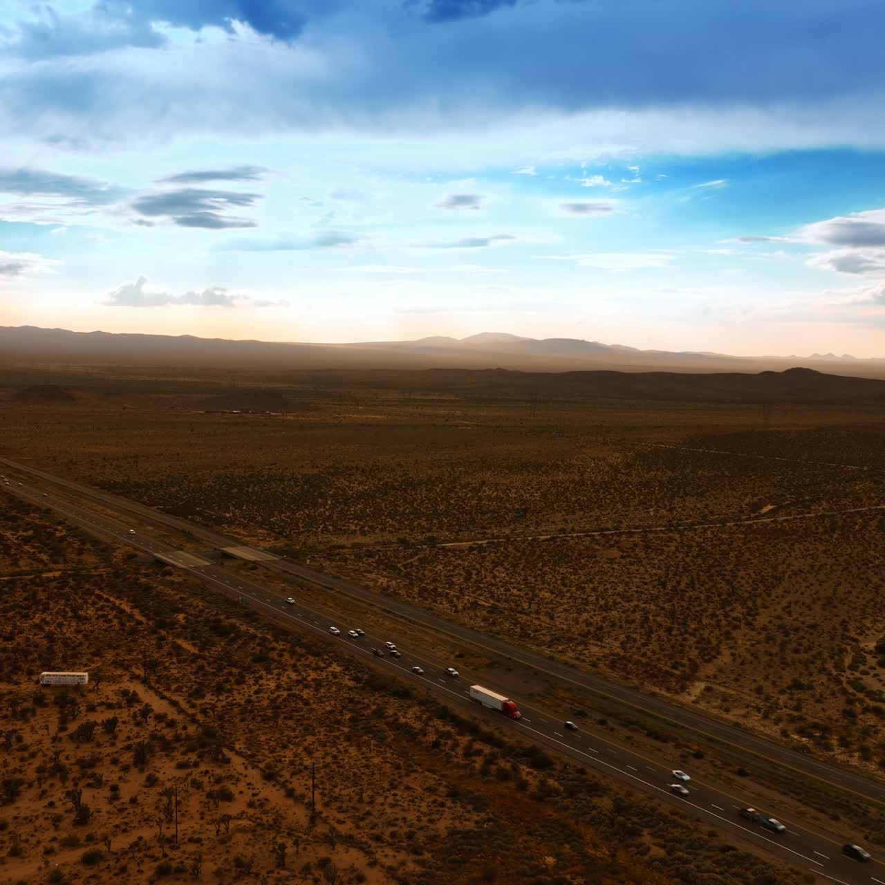 Scenery of Death Valley after sunset. Cars run by the speedway. Blue sky with clouds at backdrop. Aerial view