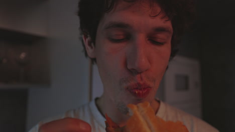 close-up of a young man enjoying a sandwich