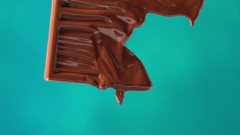 close up of melting chocolate bar against blue coloured background with copy space 3