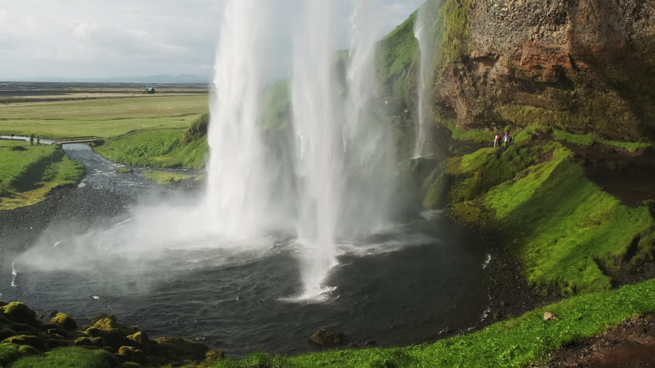 turistas explorando la hermosa cascada seljalandsfoss en islandia