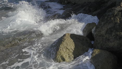 waves crashing onto rocks in slow motion