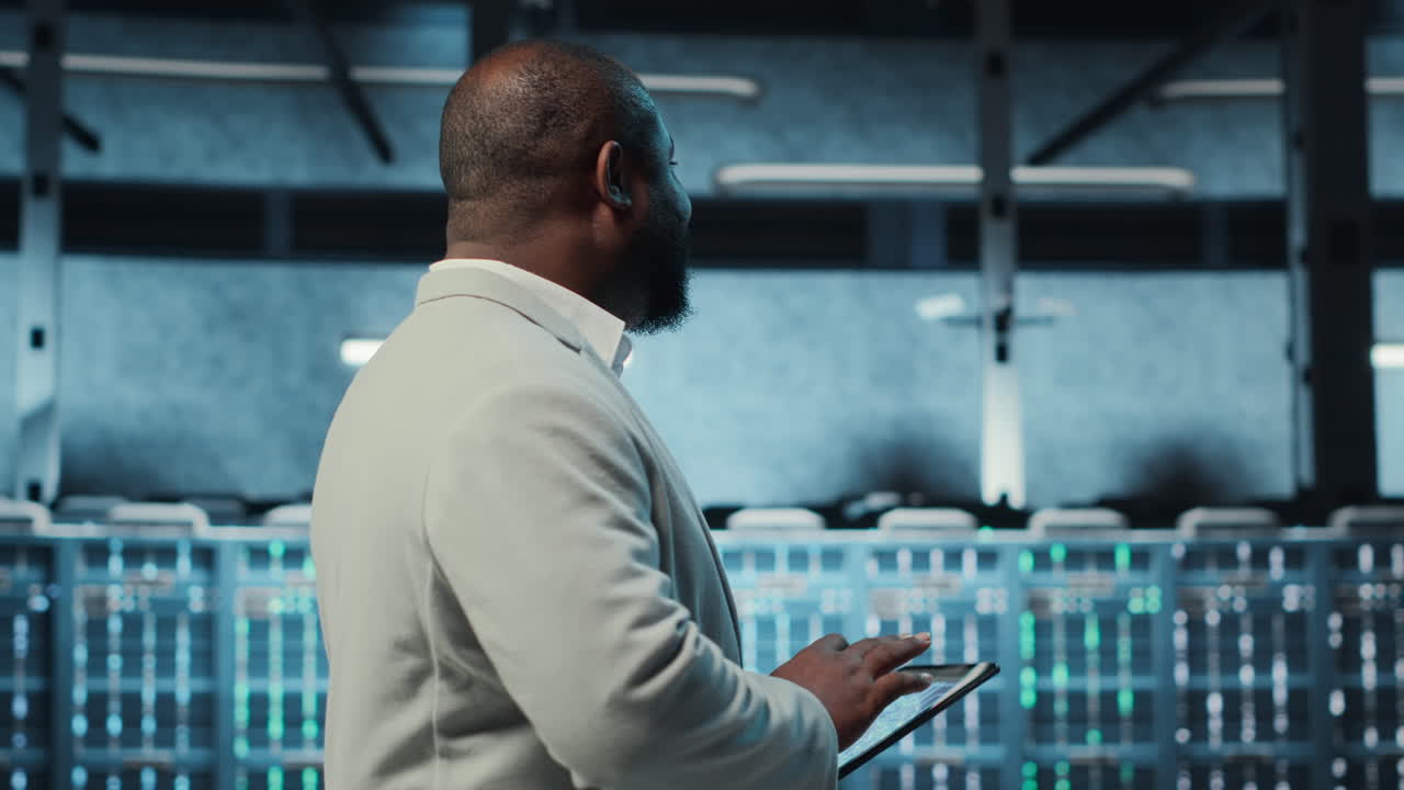Technician working in high tech server hub, analyzing data on tablet