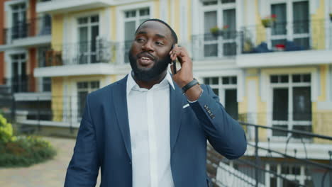 Aufgeregt-Afrikanischer-Geschäftsmann-Ruft-Draußen-An.-Afro-Mann-Spricht-Smartphone