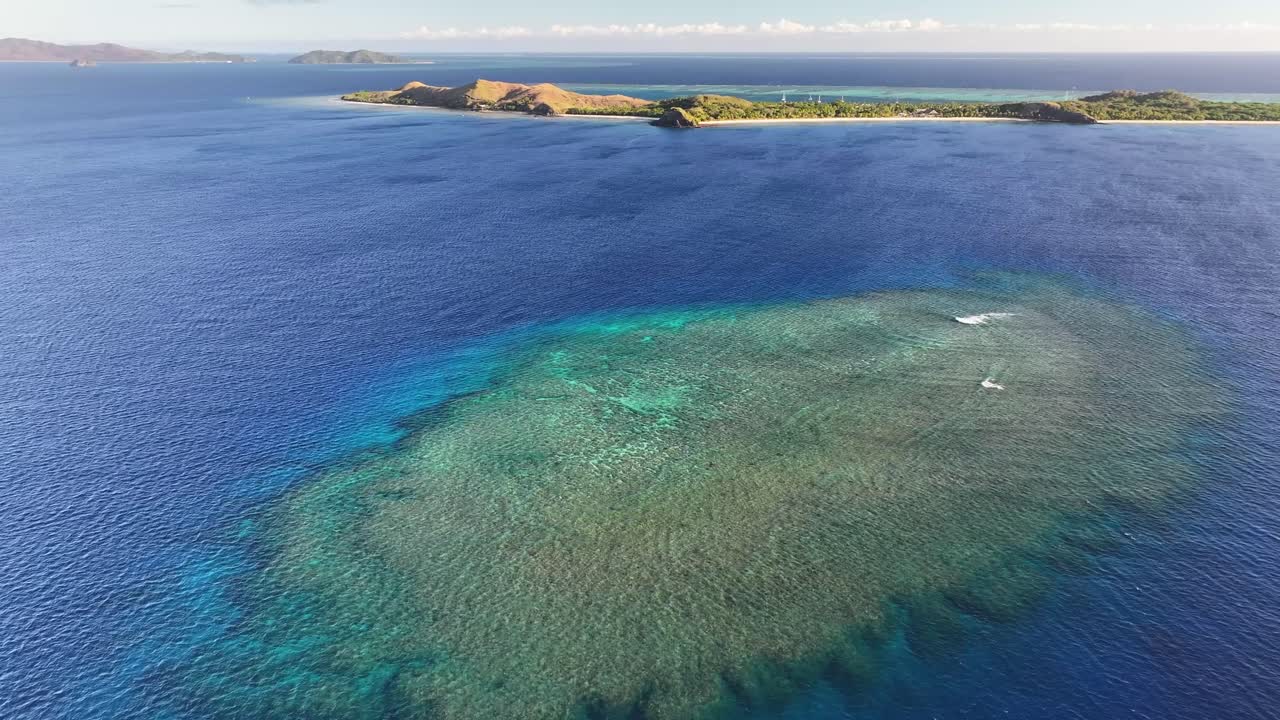 Remote coral reef and paradise island on horizon, exotic travel destination. Mana Island, Fiji