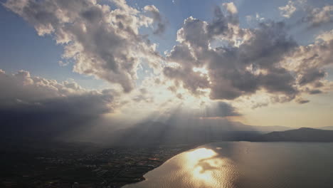 dramatic sunset with rays shining over serene lake and mountains