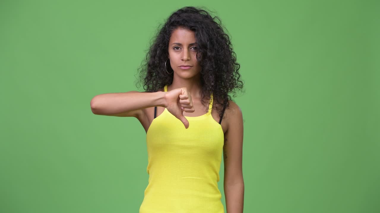 Young beautiful Hispanic woman giving thumbs down
