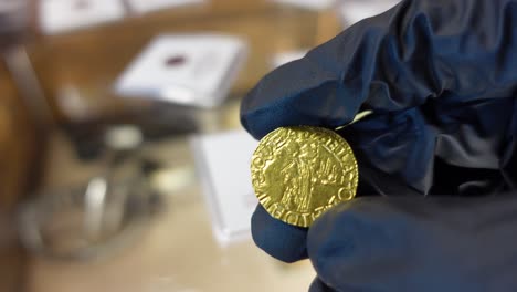 coleccionista examinando la moneda de oro portuguesa de la era de los descubrimientos