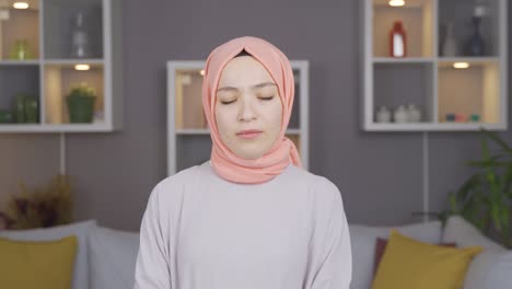 unhappy muslim woman in hijab looking at camera.