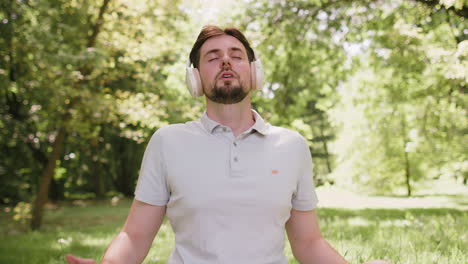 young man sitting on mat in lotus position relaxing in city park on summer day meditation relax