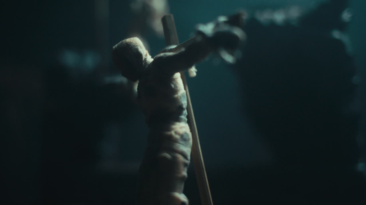 A miniature mummified dolls hanging on the gallows at night