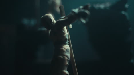 a miniature mummified dolls hanging on the gallows at night