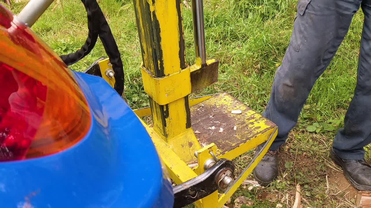 나이 든 남성 의 손 이 수압 목재 분할기 에 나무를 배치 하고 있다 - 겨울 에 사용 할 수 있는 연료