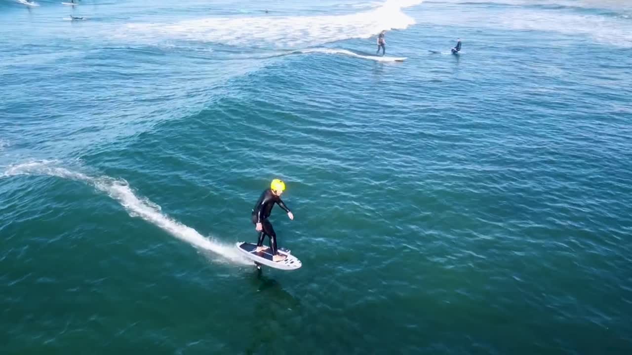 el surfista utiliza la asistencia de transmisión de láminas para atrapar olas más rápido, bombeando para generar velocidad y precisión adicionales, mejorando el rendimiento en el agua.