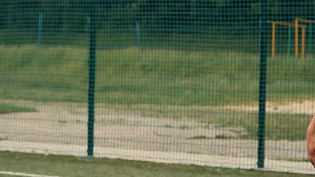 길거리 축구장에서 축구공을 들고 서 있는 알아볼 수 없는 축구 선수 가까이