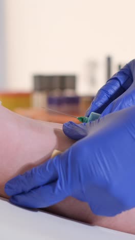 close up of doctor or nurse taking a blood sample from arm vein with a vacutainer. syringe to venipuncture the patient