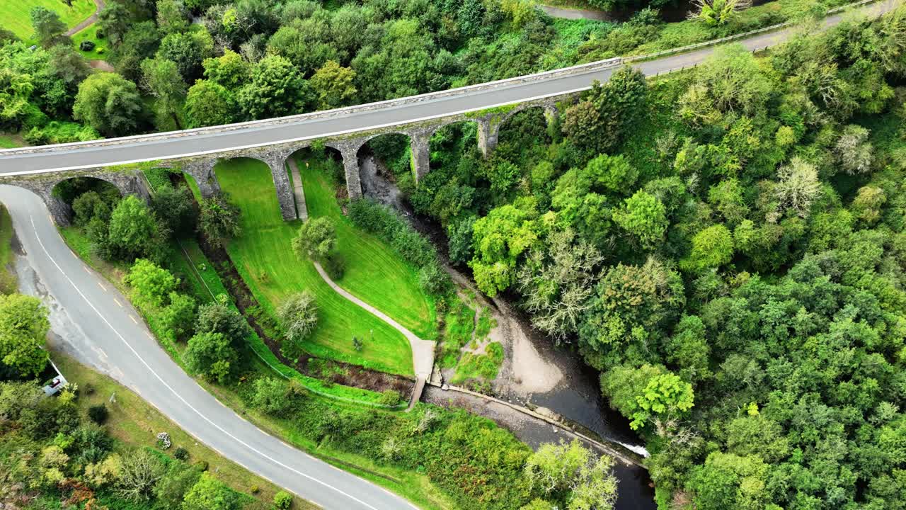 Aerial View of a Stone Bridge Over a River in a Lush Green Landscape