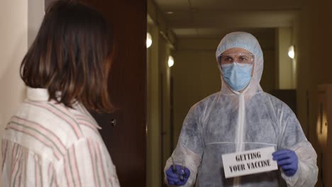 woman refusing a vaccine from a medical worker in protective gear