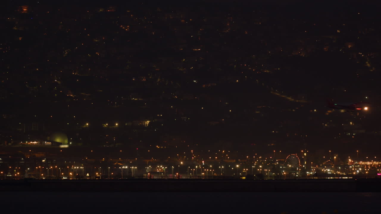 밤의 도시 배경에 비행기가 착륙합니다.