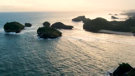 tiny volcanic island on kasap coast, java, indonesia at sunset, aerial panorama