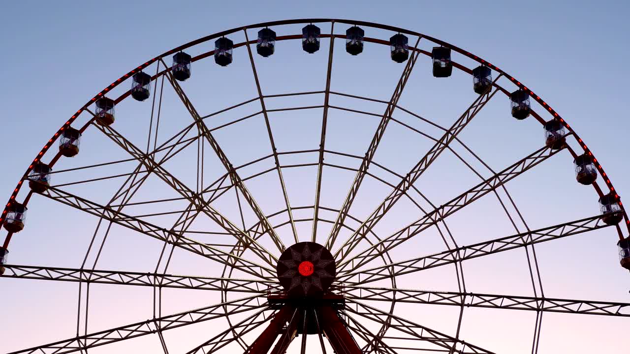 large Ferris wheel with illumination, against the sky, sunset, twilight