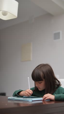 girl drawing on digital tablet at home