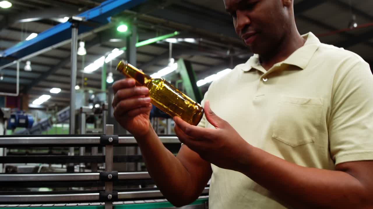Smiling worker examining a bottle