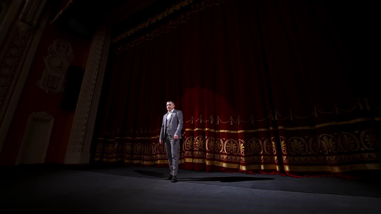 Man on stage in theater. Man speaking on stage of theatre