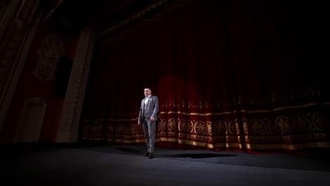man on stage in theater. man speaking on stage of theatre