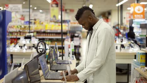 the buyer chooses a laptop in a modern technology store