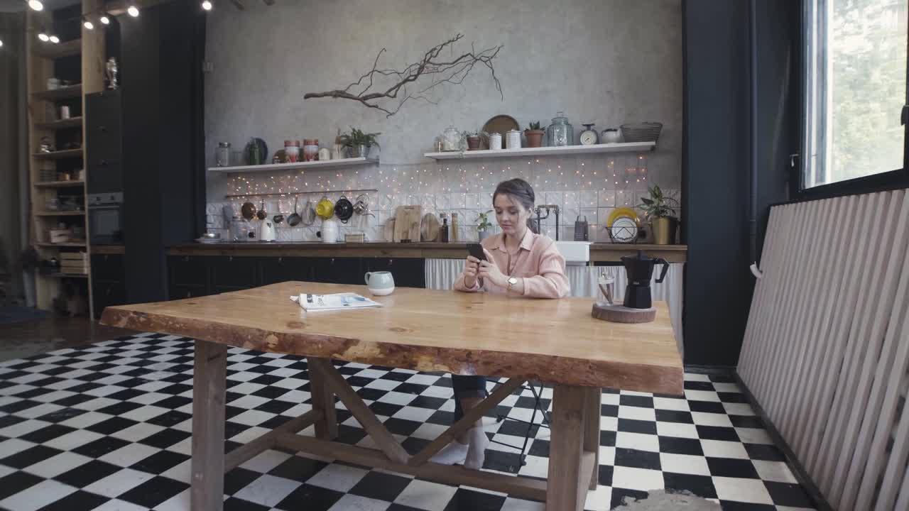mujer usando el teléfono en una cocina moderna