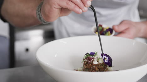 caucasian male chef decorating meal in kitchen, slow motion