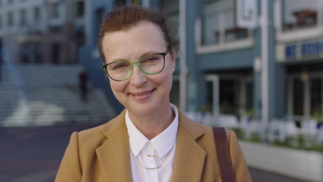 portrait of elegant mature business woman smiling confidently in urban background wearing stylish suit jacket