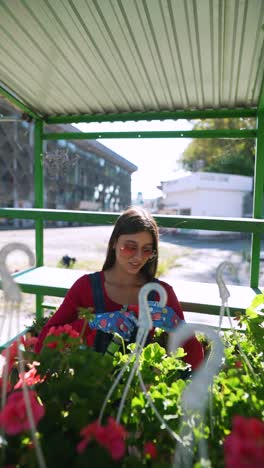 mujer cuidando flores en un centro de jardinería