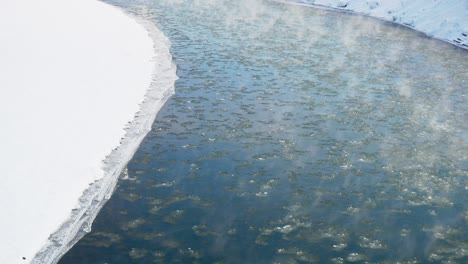 Hielo-A-La-Deriva-Que-Fluye-Por-El-Río-Cubierto-De-Nieve